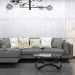 Modernes Wohnzimmer mit grauer couch, betonwand und schwarzen Designakzenten im minimalistischen Stil